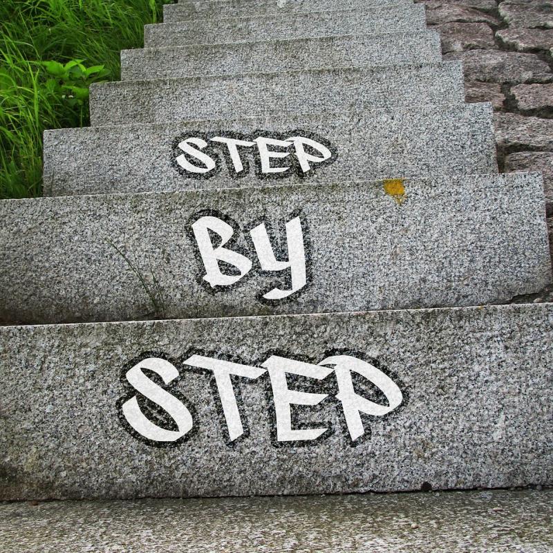 Stairs going upward with words saying "step by step"